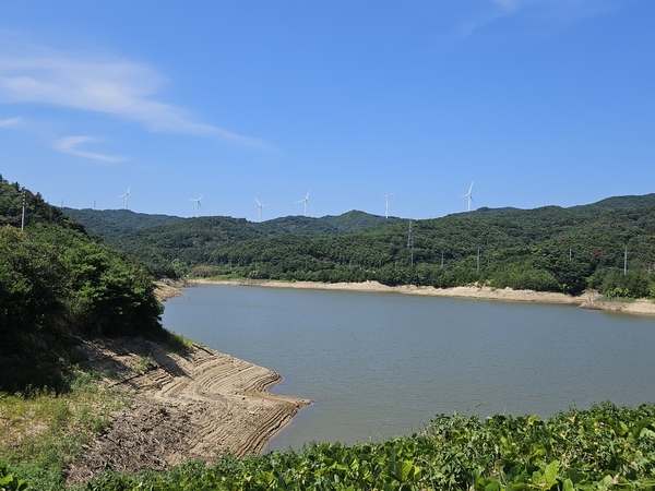 ▲ 저수지 둑에서 바라본 저수지 전경과 풍력발전설비의 모습 ⓒ이정택 기자