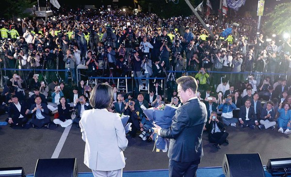 ▲ 제21대 대통령 당선이 확실시되는 더불어민주당 이재명 대선 후보와 부인 김혜경 여사가 4일 서울 여의도 국회 인근에서 당 주최로 열린 국민개표방송 행사에 참석해 꽃다발을 받은 뒤 시민들과 소통하고 있다. ⓒ연합