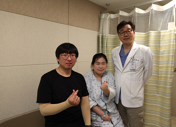 ▲ 급성 심근경색 진단을 받은 후 응급 관상동맥중재술 시술을 받고 건강을 회복한 A(가운데)씨와 남편, 포항세명기독병원 정항재 진료처장(심장센터장)이 기념 촬영하는 모습. ⓒ포항세명기독병원