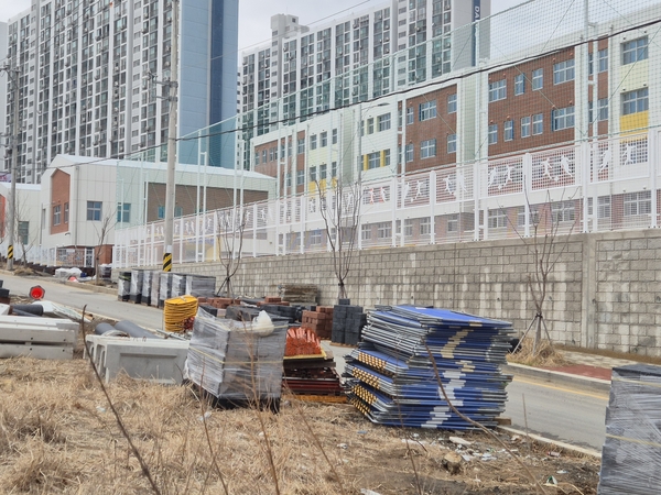 ▲ 달전초 옆길에 공사자재들이 아슬아슬하게 방치돼 통행 아동들이 사고위험에 노출되고 있다. ⓒ영남경제 자료